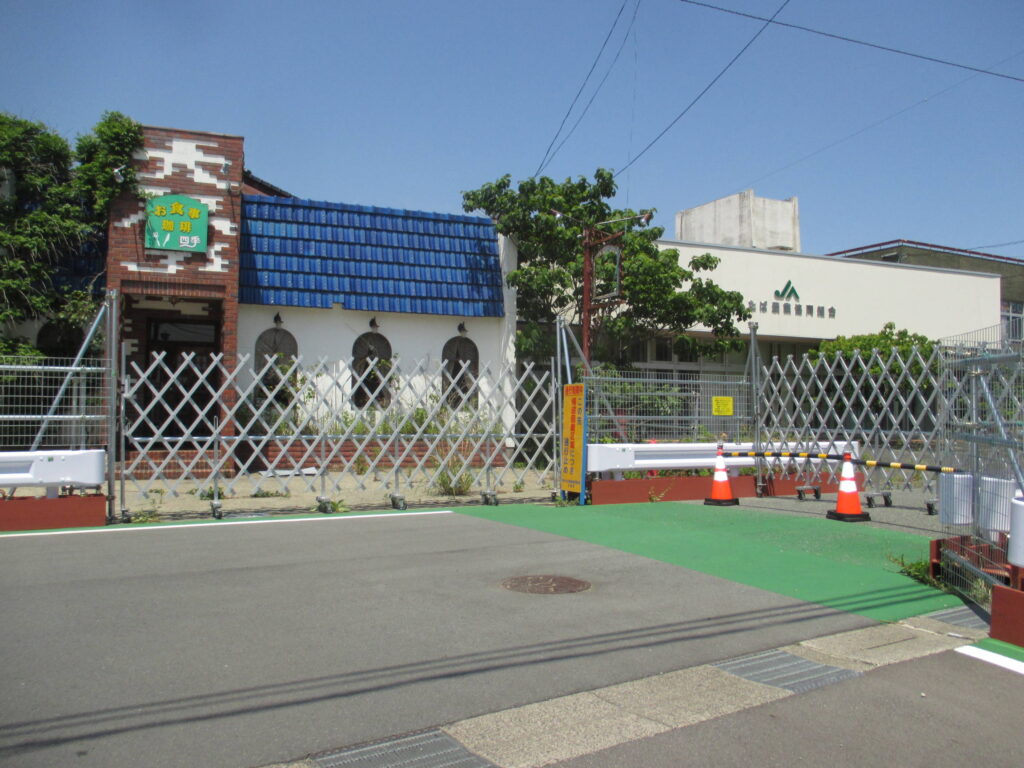 JAの入口は道路に可動フェンスが置かれている。隣の店舗は入口に可動フェンスが置かれている